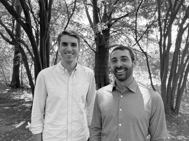 Two men standing in front of a river